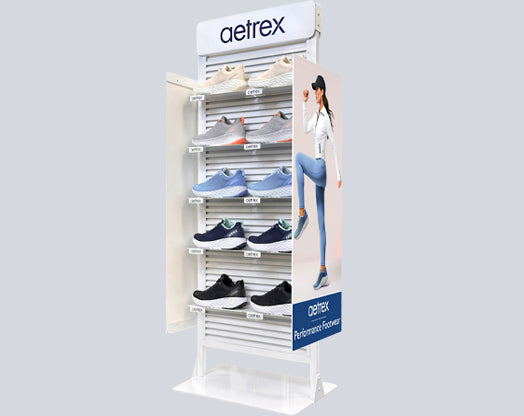 Shoe display rack with various shoes on a gray background, featuring the brand 'aetrex'.